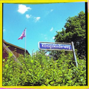 Die Schnelsen-Flagge im Vorgarten ­hat mit Tradition wenig zu tun: Es gibt sie erst seit 2010. Sie zeigt das letzte Bauernhaus Schnelsens, den Born- kasthof, zwei Meilensteine und – ganz unromantisch – einen  Verkehrsknotenpunkt.   