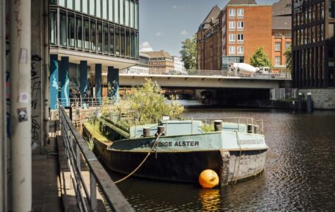 Im Innern der grünen Schute, die auf Höhe Admiralitätsstraße 10 ankert, wachsen sogar Wasserpflanzen, da die Unterseite geöffnet ist. Foto: Miguel Ferraz