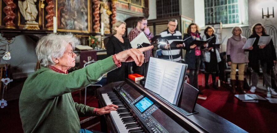 El Maestro: Michael Horn-Antoni dirigiert vom Klavier aus die Mitglieder des Chors der Kirchengemeinde Haselau. Foto: Dmitrij Leltschuk