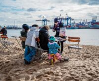 Hinz&Künztlerin Jasmin verkauft das Straßenmagazin regelmäßig am Elbstrand in Övelgönne. Foto: Dmitrij Leltschuk