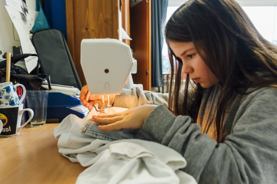 Hochkonzentriert: Rosa setzt ihre Upcycling-Idee an der Nähmaschine um. Foto: Miguel Ferraz